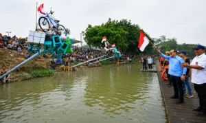 Unik! Panjat Pinang Miring di Atas Air, Ribuan Warga Padati Jakabaring